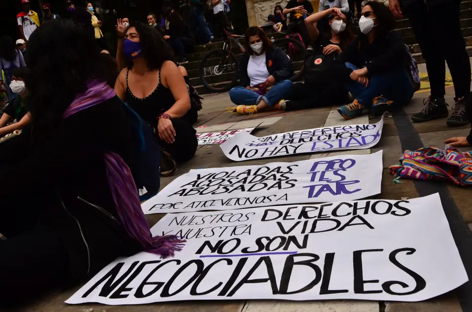 Grupo de mujeres con carteles denunciando violación de derechos humanos en Colombia