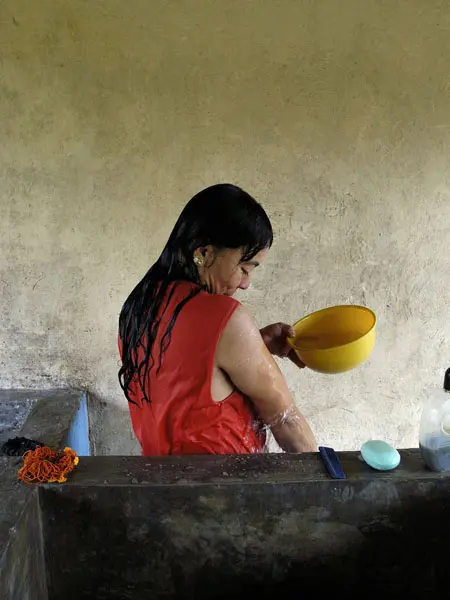 La gente desplazada sufre muchas carencias, sobre todo en los primeros días, y lo que siempre se pierde es la intimidad de la casa propia, ya que tienen que compartir con la comunidad servicios básicos como el baño. En la foto, una mujer se lava en uno